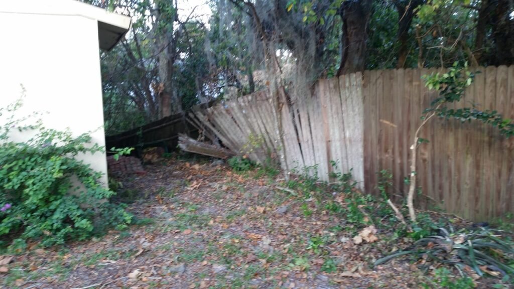 Old wood fence leaning and falling apart