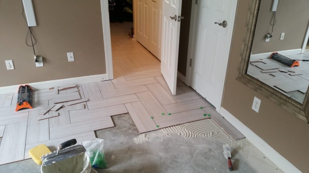 Bedroom slab partly covered as herringbone tile installation begins