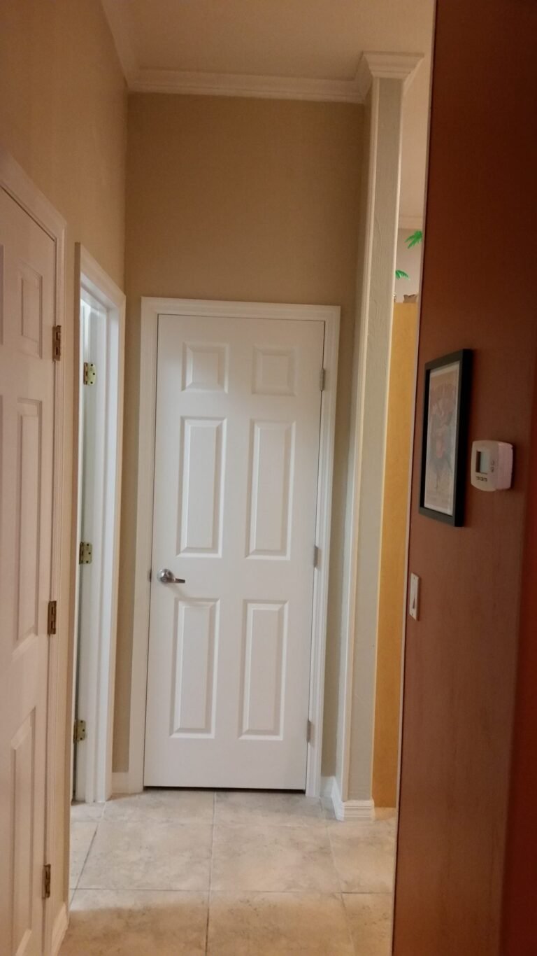 New white interior doors and trim installed along a hallway