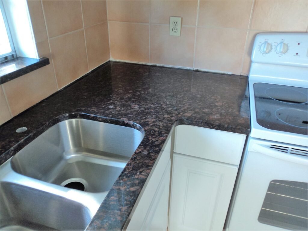 New white cabinets with dark granite countertops