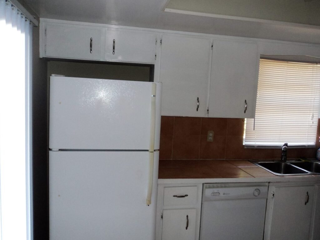 Dated kitchen with old cabinets and tile countertops