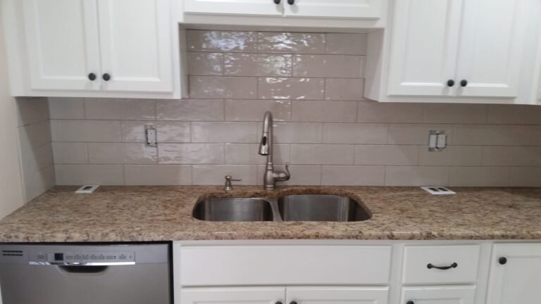 Kitchen with white cabinets, granite counters and a subway tile backsplash