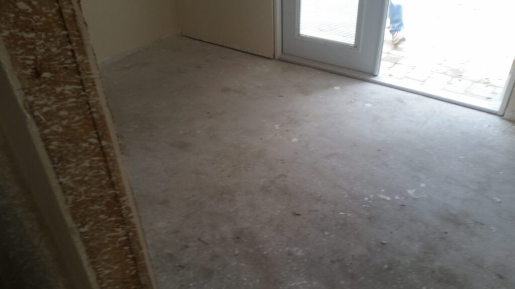Empty room with a bare concrete slab before tile