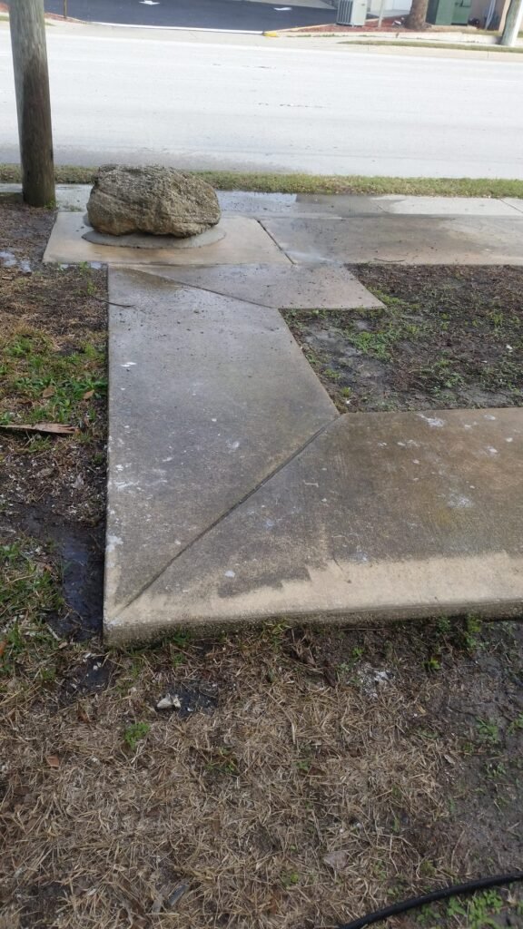 Cracked and stained concrete walkway before refinishing